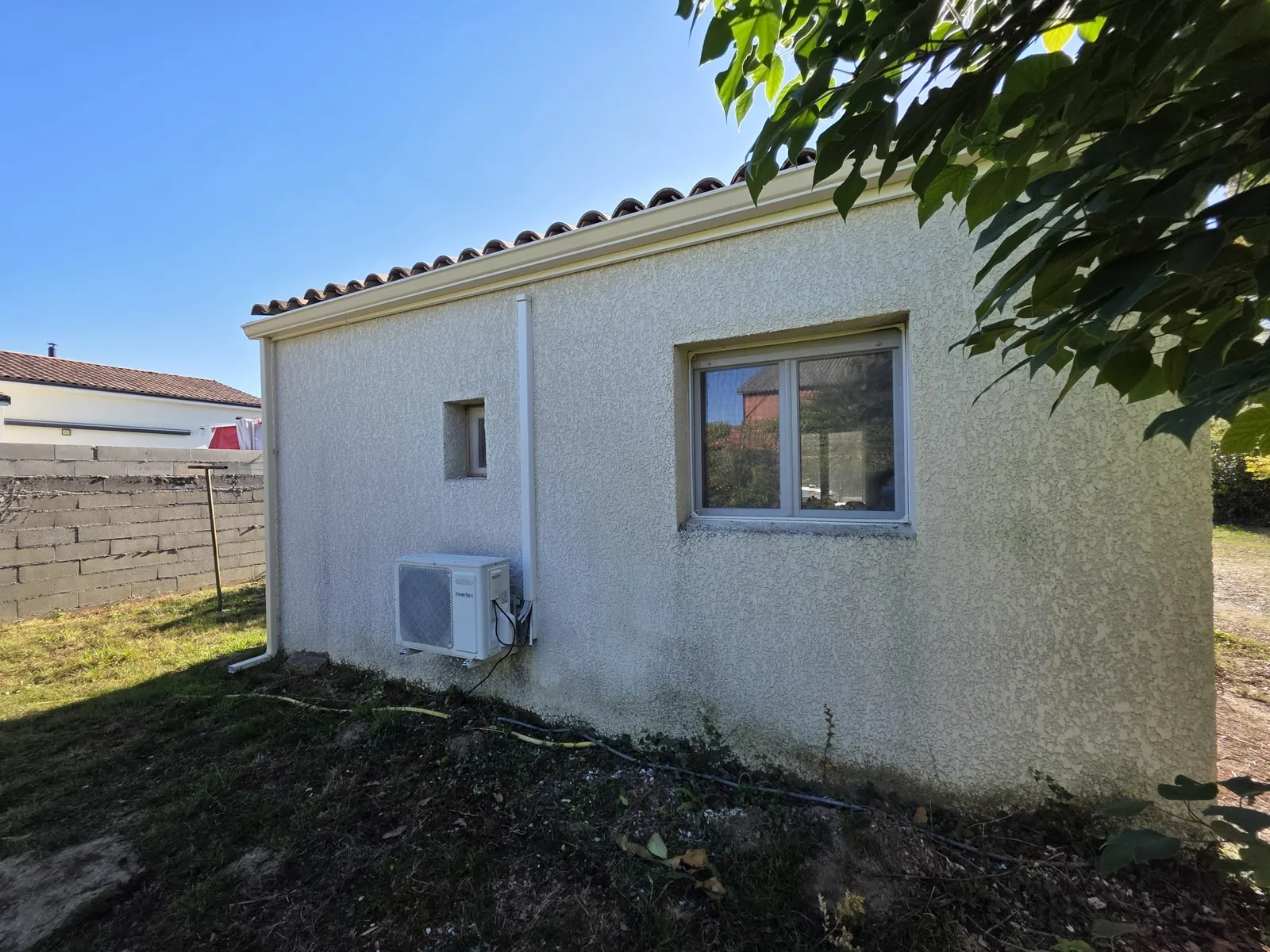 Pignon d'une maison de plain-pied à Balma après travaux, avec sa rive et une descente en aluminium blanc