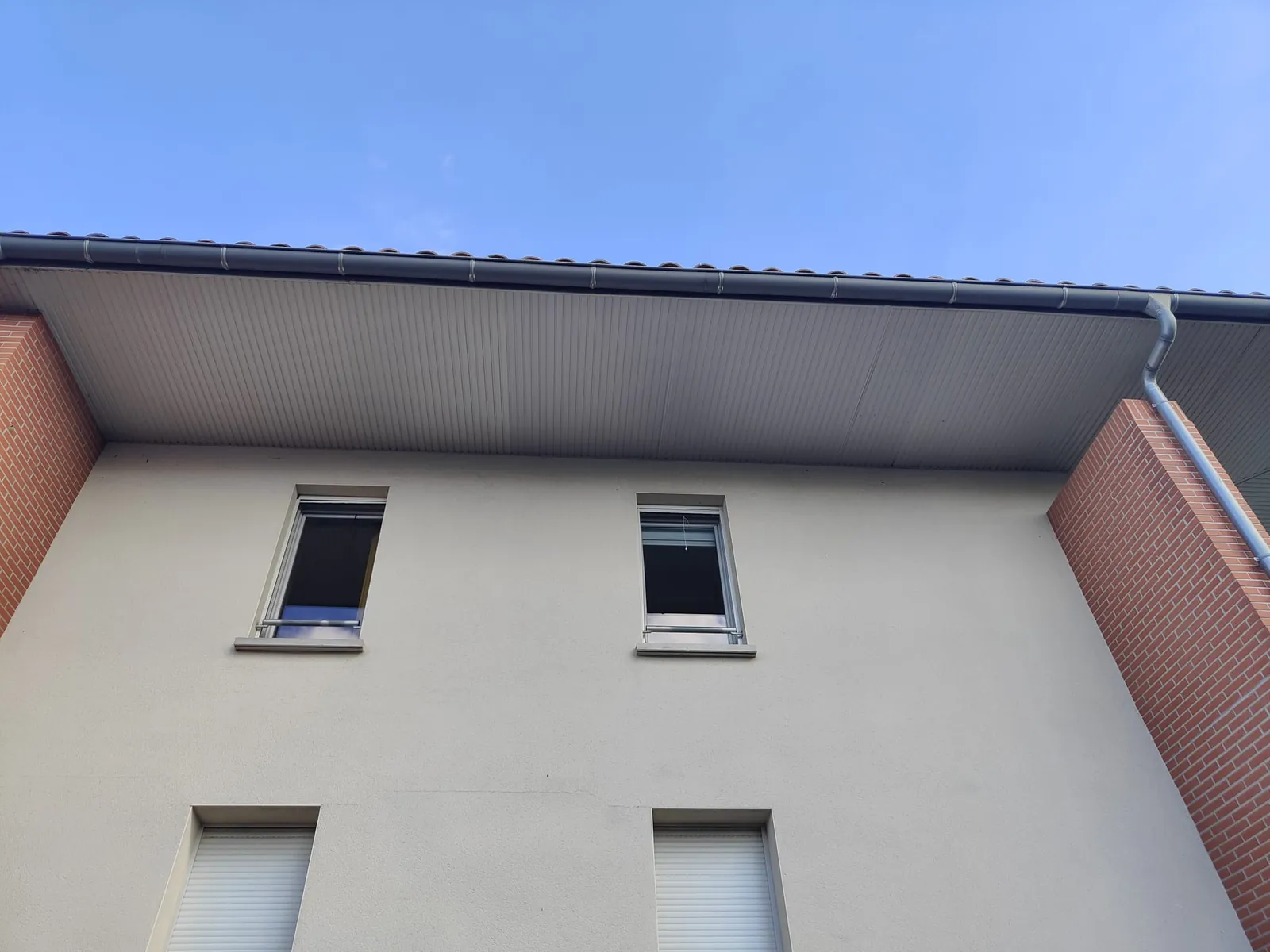 Après les travaux : Sous-face du débord de toit de l'immeuble, au-dessus des fenêtres du dernier étage