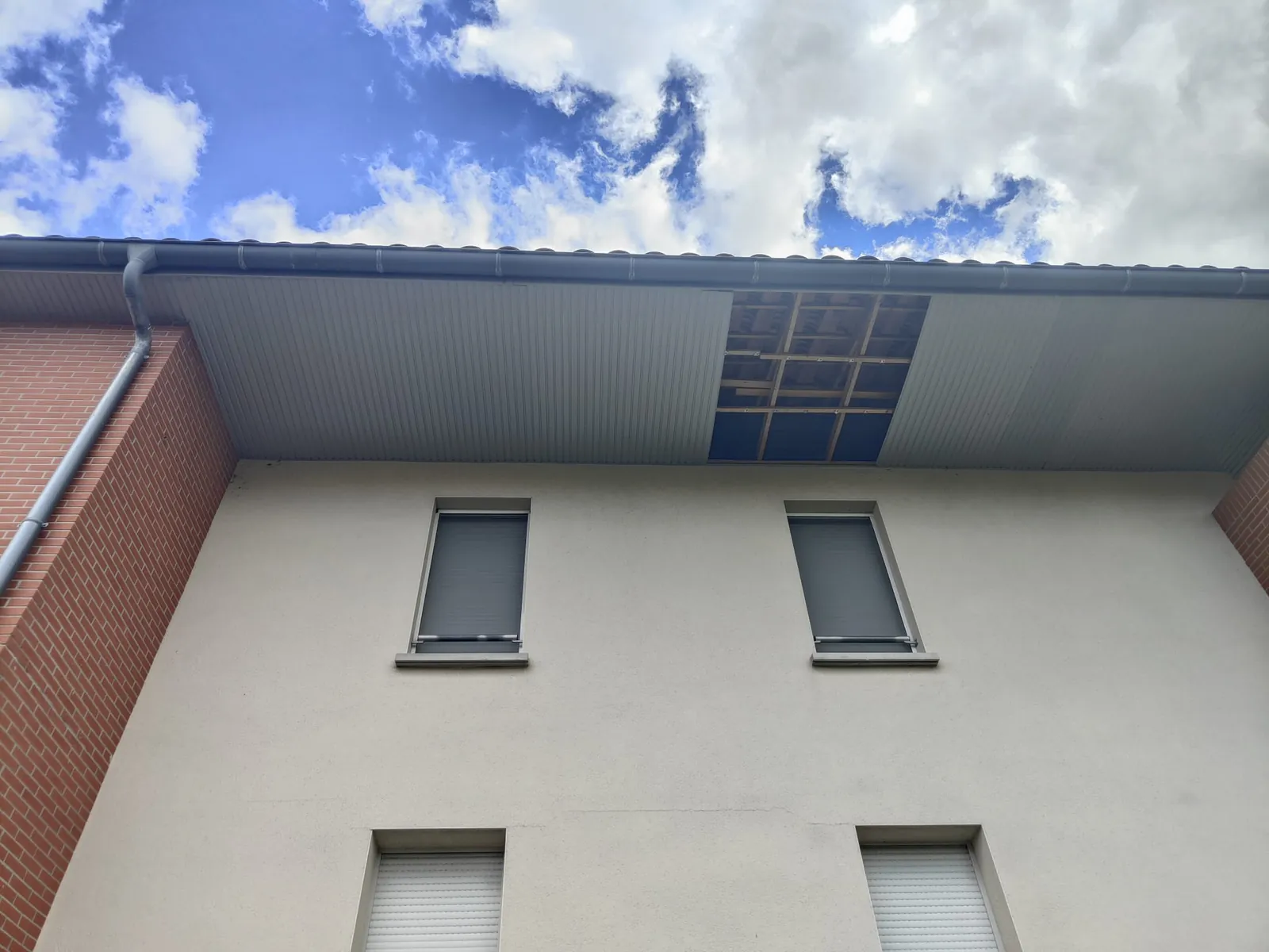 Avant les travaux : Sous-face du débord de toit de l'immeuble, au-dessus des fenêtres du dernier étage