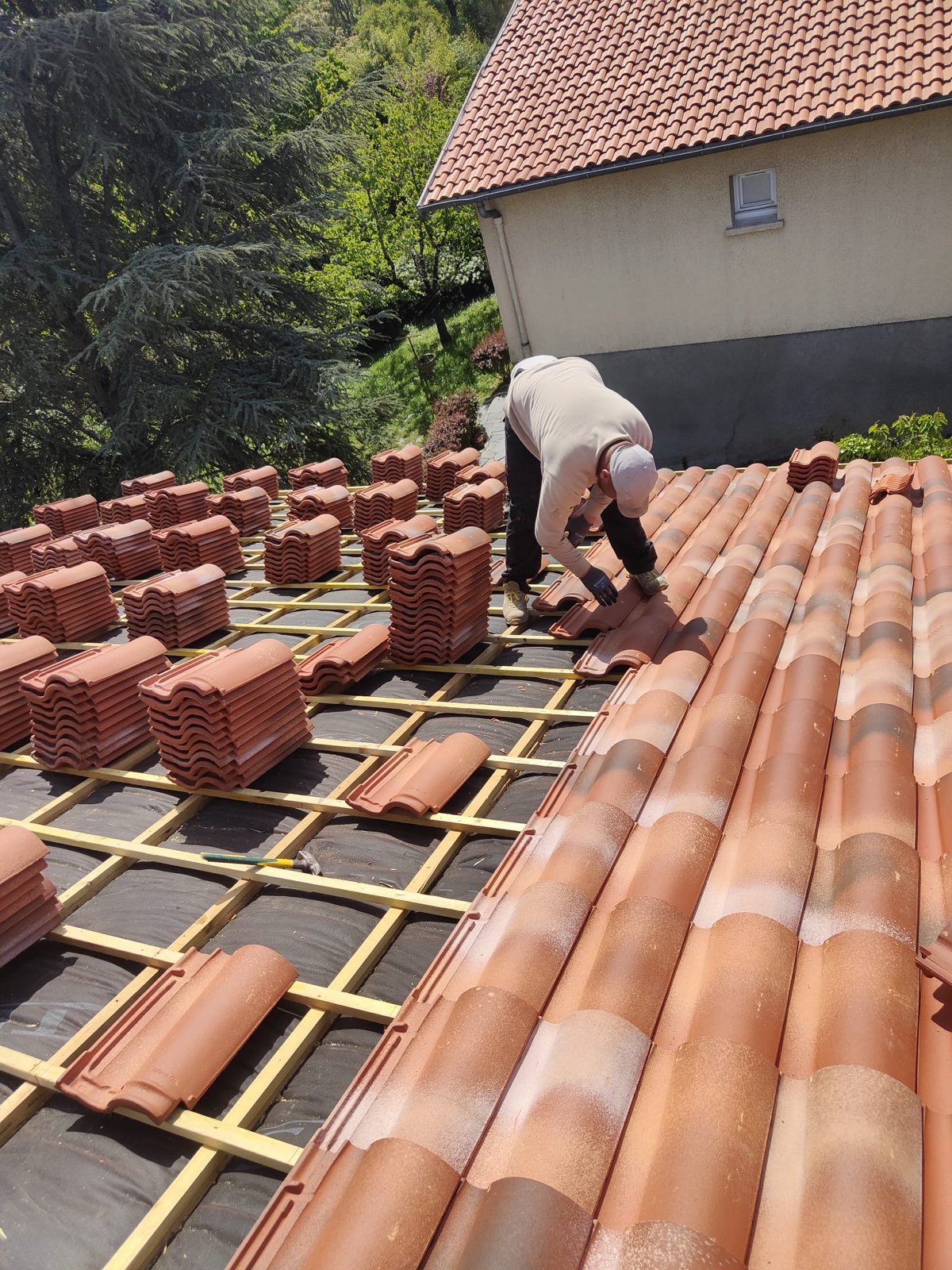 Couvreur posant une couverture neuve en tuiles sur une toiture rénovée à Toulouse