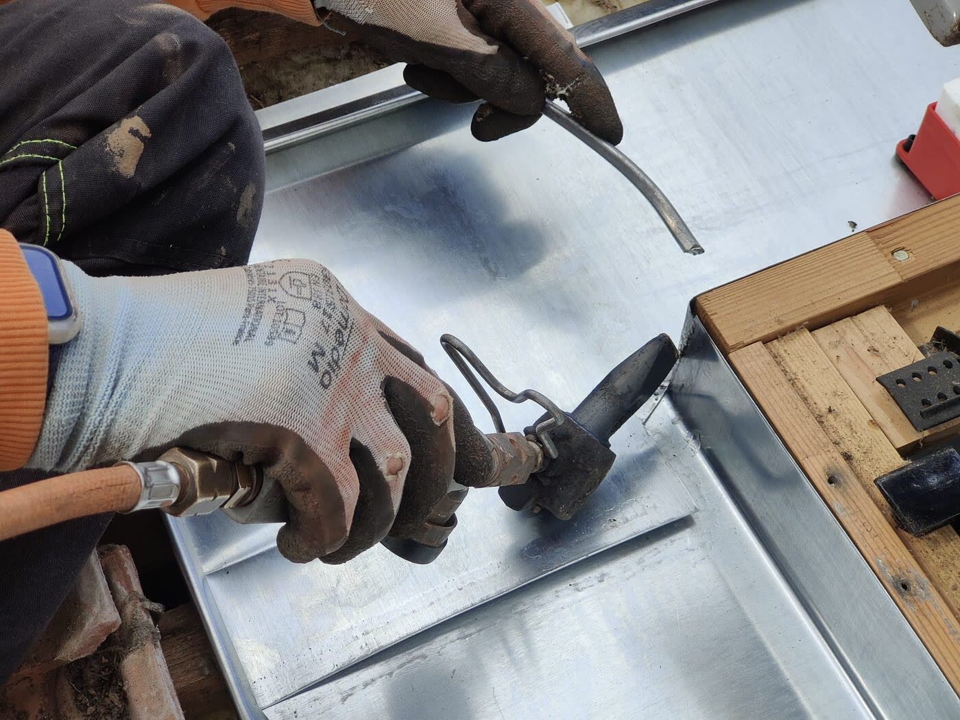Façonnage sur mesure d'une pièce de zinc par un couvreur zingueur