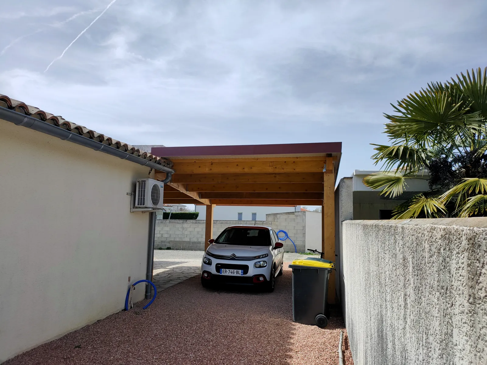 Abri de voiture en ossature bois avec toiture monopente accolé à une maison