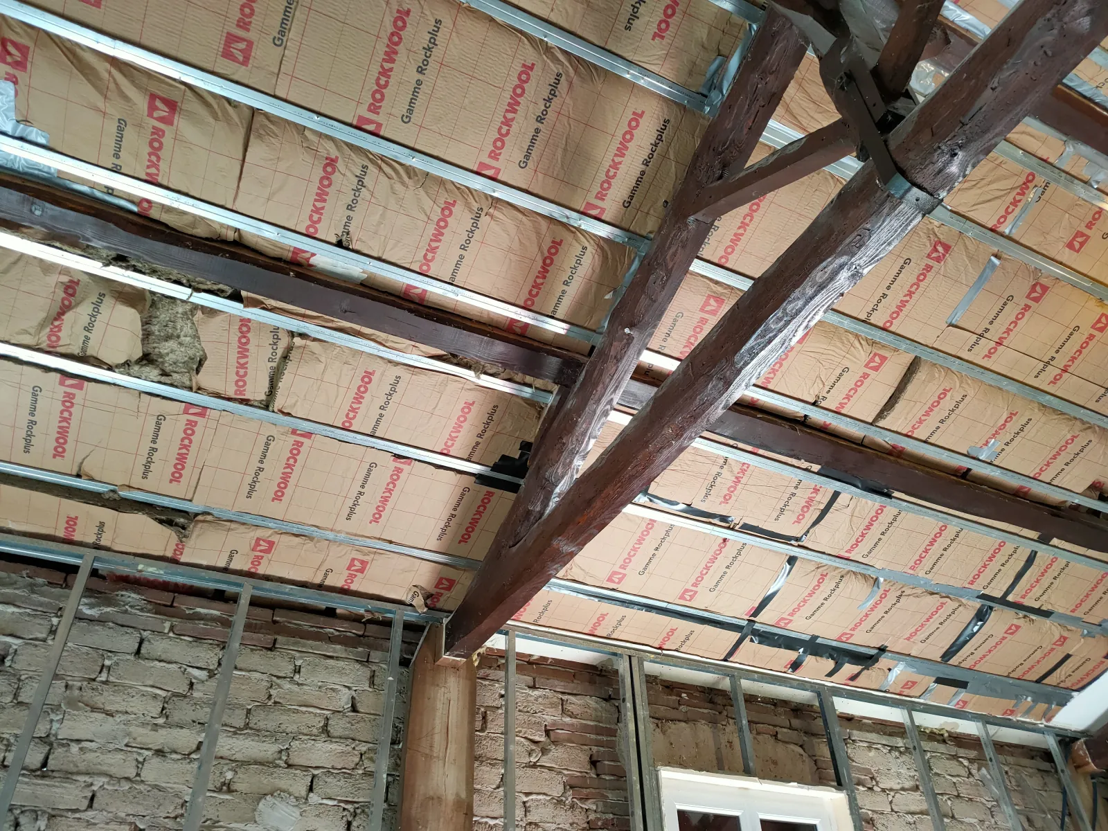 Isolation des rampants en laine de roche sur ossature métallique avec poutre bois centrale