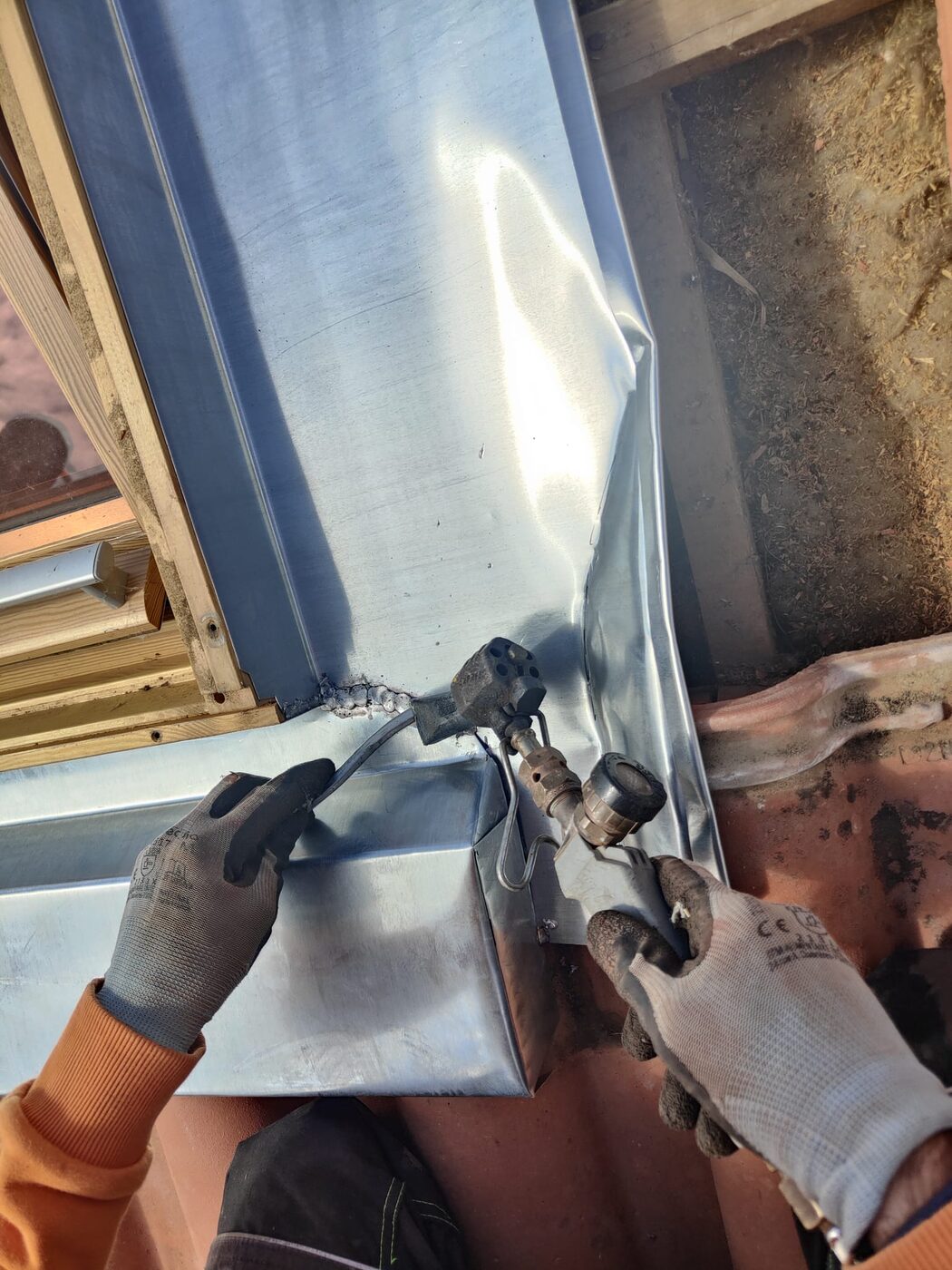Soudure d'une pièce de zinc pour l'étanchéité de la toiture