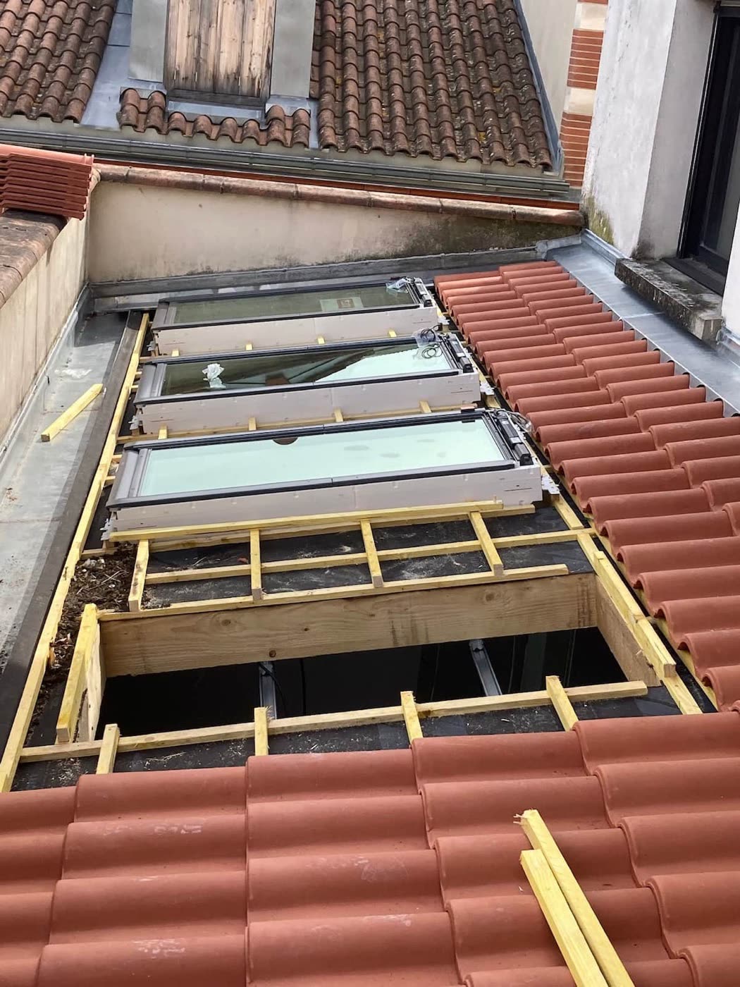Pose de trois fenêtres de toit Velux alignées avec chevêtre bois