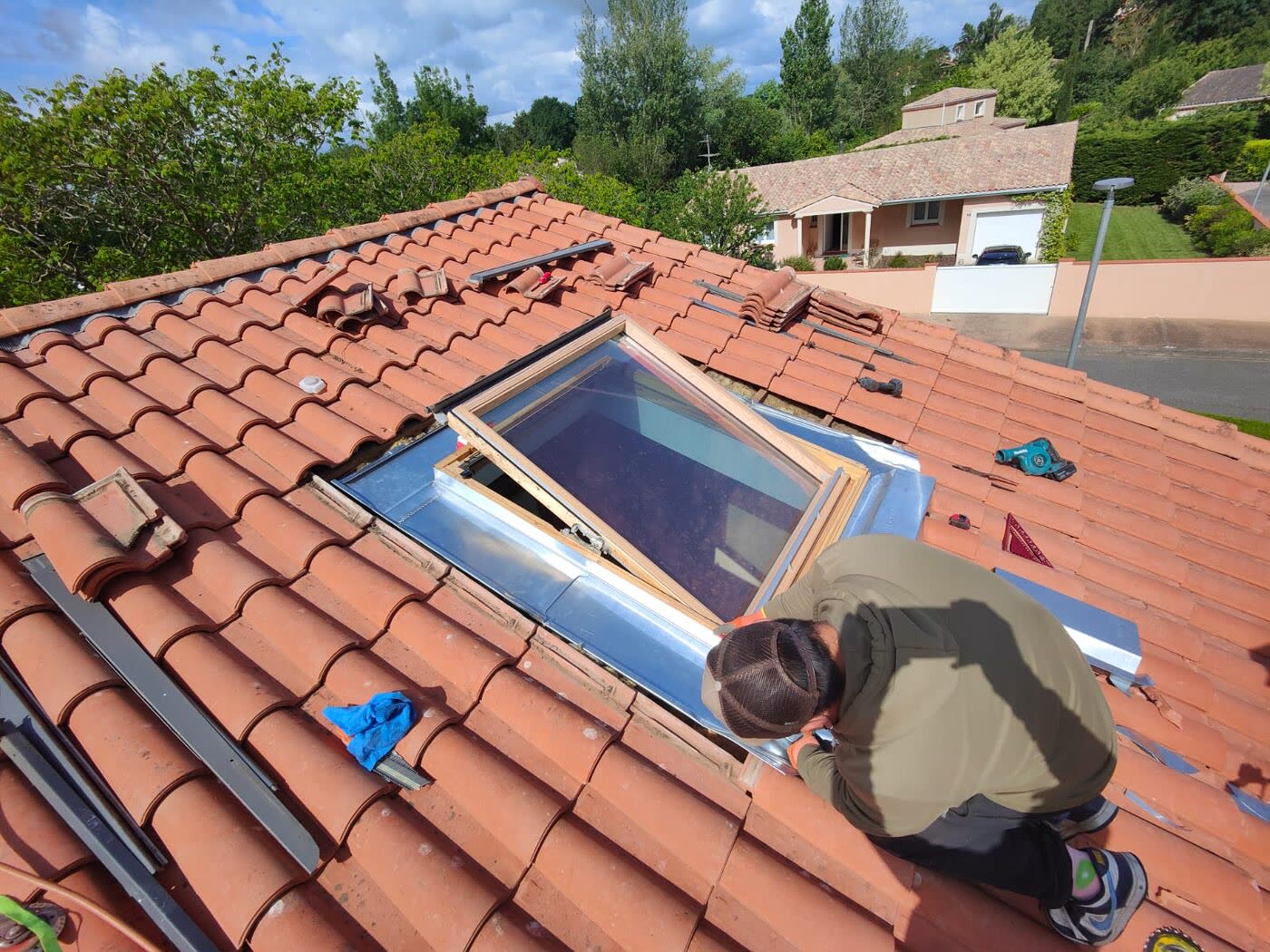 Pose d'une fenêtre de toit Velux par un couvreur sur toiture en tuiles
